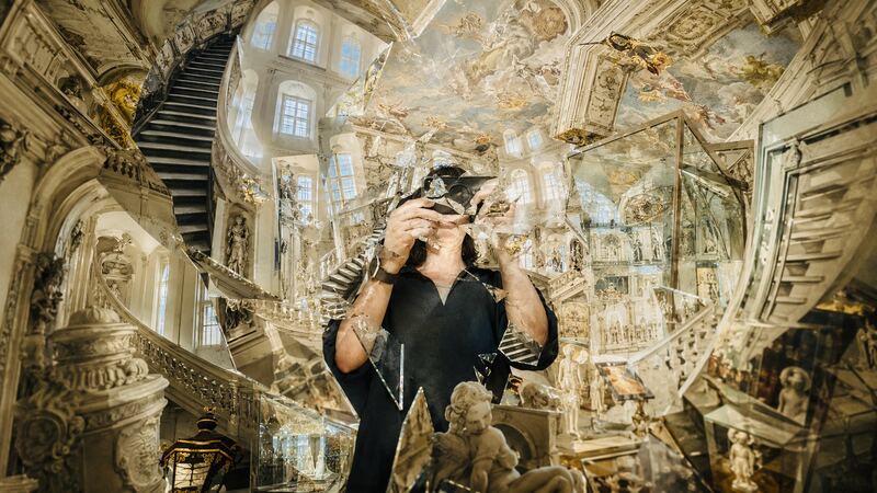 Selbstbildnis mit Apparat — Der Fotograf im zerfallenden Stiegenhaus, die Kamera vor dem Gesicht. GöttwAIg Wunderkammer(21), AI-Bildcollage.