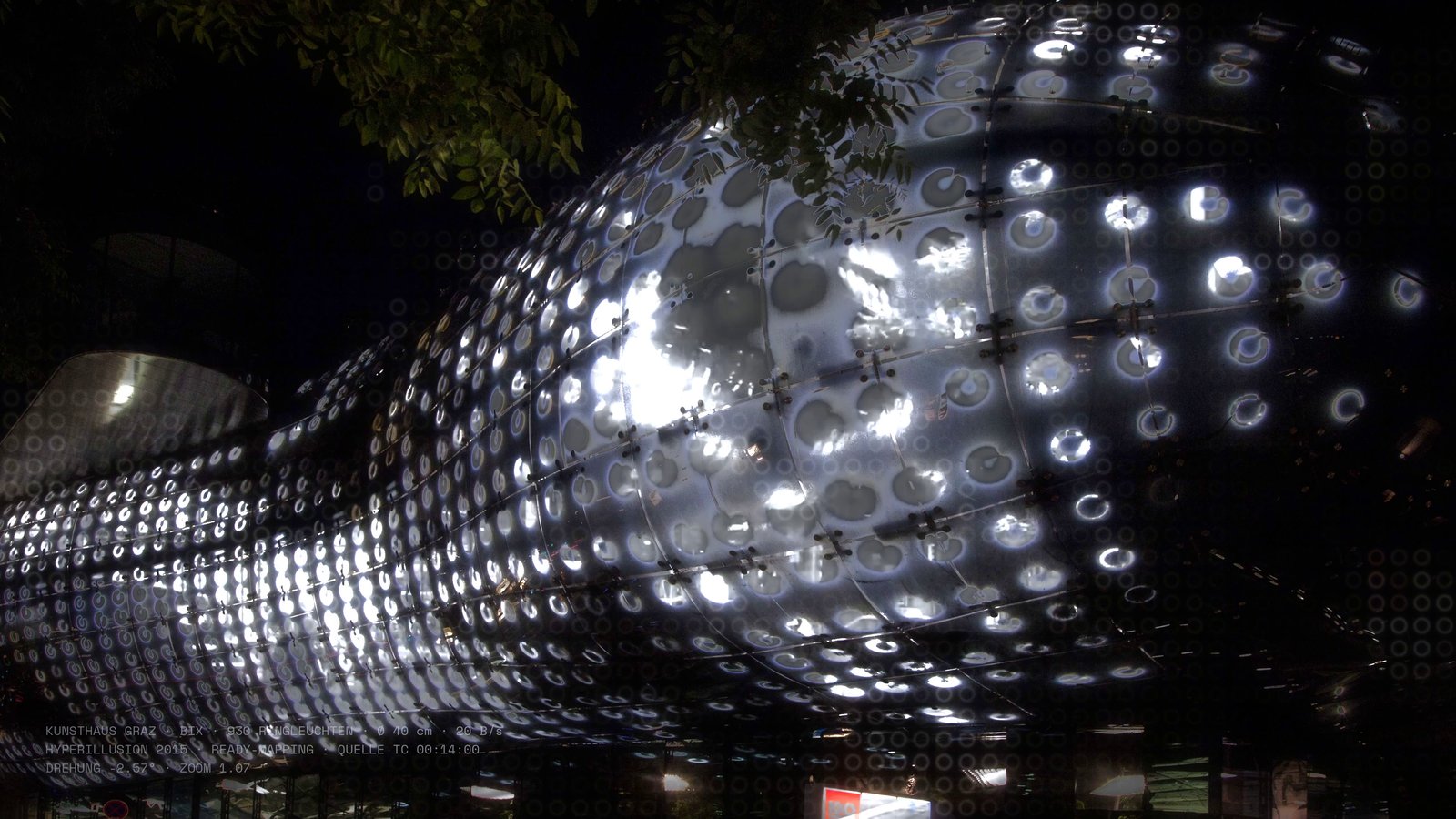 Kapitel I: Fassadenfoto des Kunsthauses, dessen Ringlampen das Hyperillusion-Video wiedergeben